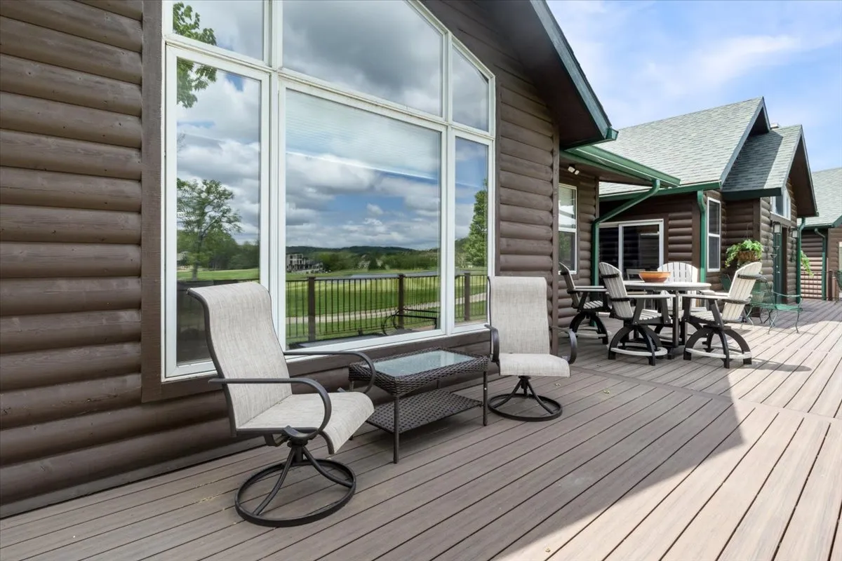 A comfortable outdoor seating area with a dining table and large windows that offer scenic views of the surrounding landscape. The space invites guests to relax, share meals, or simply enjoy the tranquil ambiance, seamlessly connecting indoor comfort with the beauty of the outdoors.