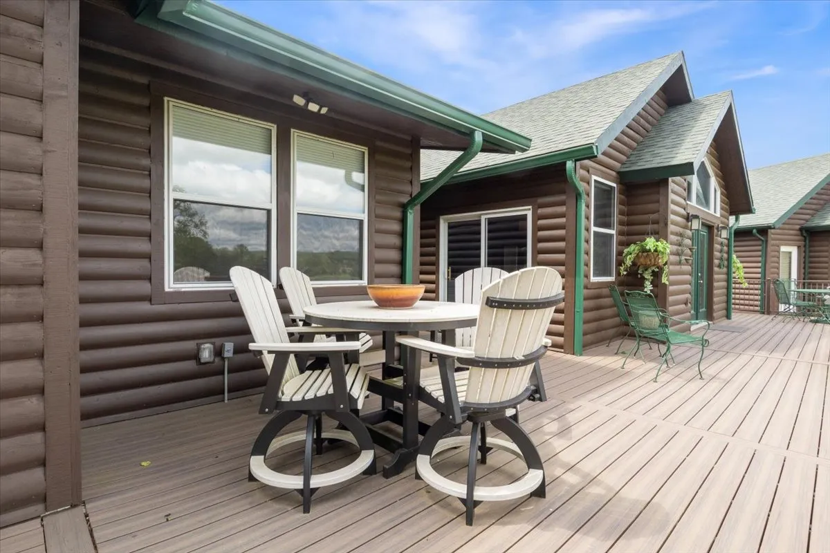 An outdoor dining table set amidst attractive wooden architecture and potted greenery, radiating a sense of friendly relaxation. It's a welcoming space for al fresco meals or morning coffee with a view.